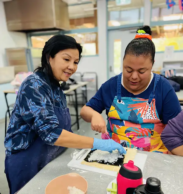 Danielle learning to make sushi with worker