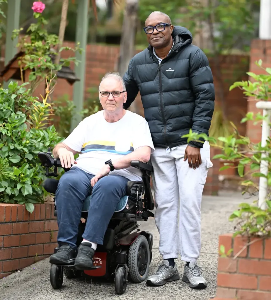 Tony outside in chair with support worker